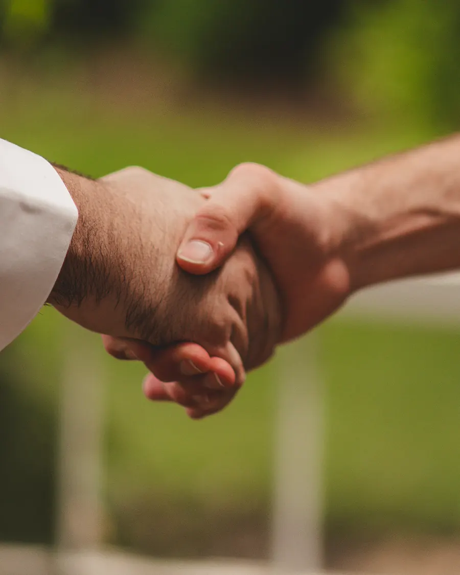 Two people shaking hands outdoors