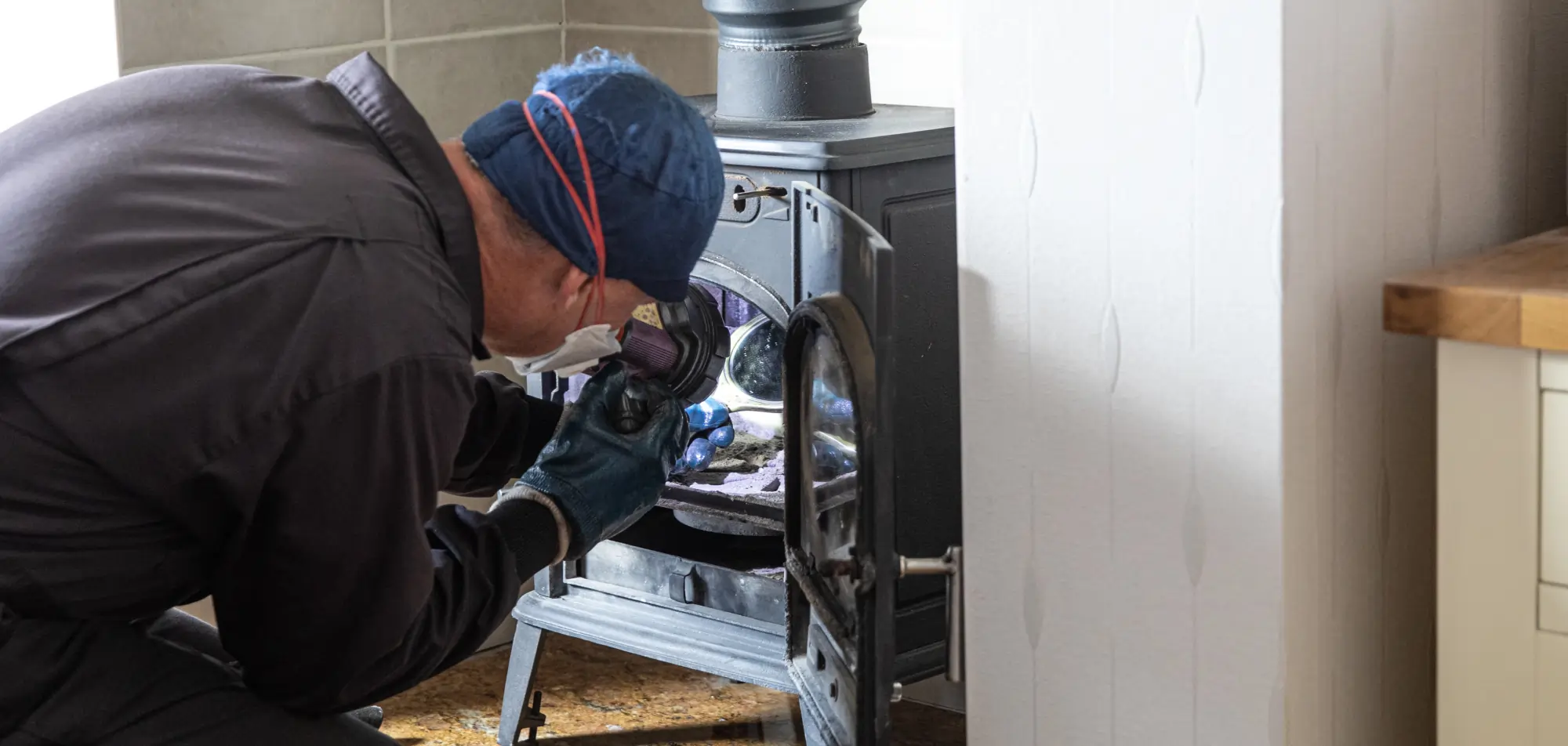 Technician inspecting a fireplace firebox and venting system