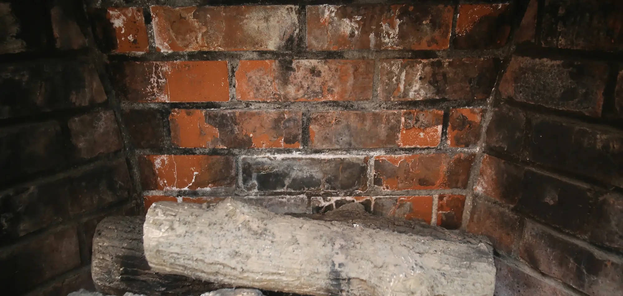 Close view of brick fireplace masonry requiring repair