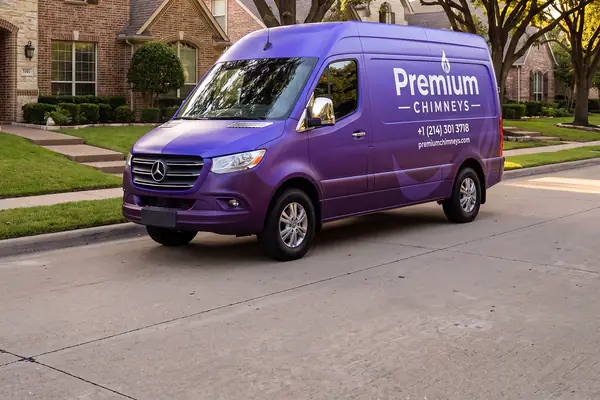 Purple Premium Chimneys service van parked outside a brick home